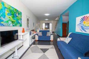 a living room with a blue couch and a tv at GuestReady - 9C House in São Vicente Ferreira