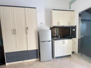 una cucina con mobili bianchi e un frigorifero di Lake Side Serenity a Ksamil Altre 38 foto