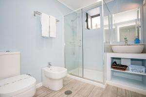 a bathroom with a toilet and a sink and a shower at GuestReady - Florbela Apartment in São Vicente Ferreira +21 photos