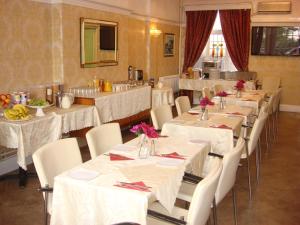 un comedor con mesas blancas y sillas blancas en Yellow Mountain Hotel, en Skegness
