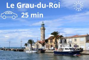 ein Leuchtturm in einer Stadt mit Booten im Wasser in der Unterkunft Maison Solèna in Gallargues-Le-Montueux