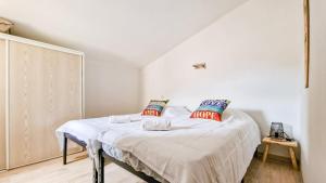 a bedroom with a bed with white sheets and pillows at Maison Solèna in Gallargues-Le-Montueux +42 photos