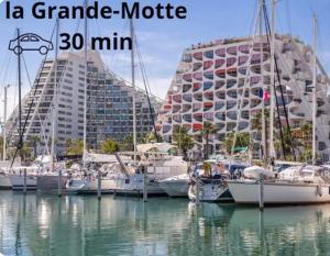 eine Gruppe von Booten, die in einem Yachthafen mit einem Gebäude angedockt sind in der Unterkunft Maison Solèna in Gallargues-Le-Montueux + 42 Fotos