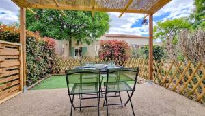 ein Tisch mit zwei Stühlen unter einer Pergola in der Unterkunft Maison Solèna in Gallargues-Le-Montueux