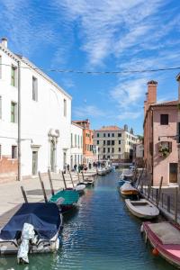 a group of boats parked in a canal with buildings at Inlaguna in Venice