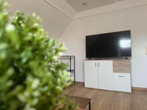 a living room with a flat screen tv on a wall at LlVINQ 11 in Emstek