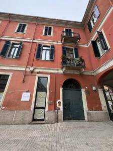 a red building with a door and a balcony at il glicine guest house in Alessandria