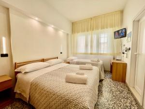 a hotel room with two beds with towels on them at Hotel Altamarea Cesenatico in Cesenatico +23 photos