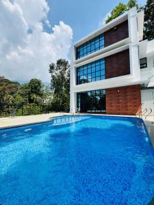 a swimming pool in front of a building at AYD-IN BY GREENLEAVES Resort in Vythiri