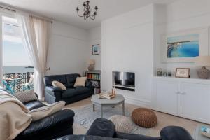 a living room with a couch and a table at Balcony Apartment in Swanage
