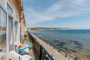a balcony of a building with a view of the ocean at Balcony Apartment in Swanage
