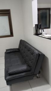 un divano in pelle nera, seduto in una stanza di Apartamento Novo, Lindo e Confortável prox Centro a Gravataí
