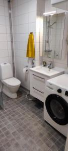 a bathroom with a washing machine and a toilet at Modern studio near Airport with Self check-in in Vantaa