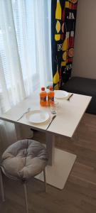 a white table with two plates and oranges on it at Modern studio near Airport with Self check-in in Vantaa