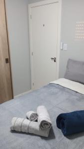 una camera da letto con due asciugamani su un letto di Apartamento Novo, Lindo e Confortável prox Centro a Gravataí