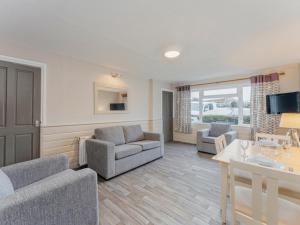 ウーラクームにあるSeashell House 2 Golden Coast Leisure Park Fのソファ2つとテーブルのあるリビングルーム +2枚の写真