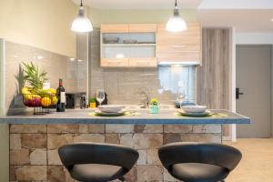 a kitchen with two black chairs at a counter at Diamond Apartments 3 in Kardamaina +7 photos