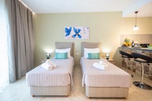 two beds in a hotel room with towels on them at Diamond Apartments 3 in Kardamaina