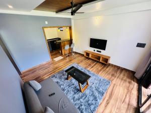 a living room with a couch and a flat screen tv at AYD-IN BY GREENLEAVES Resort in Vythiri