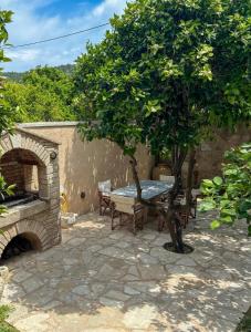 a stone patio with a table and a tree at One&Only Kalamoti Gem Retreat in Kalamoti