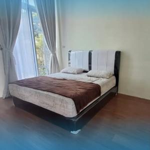 a bed in a room with a large window at Villa Zakirah By Alesta in Cilama
