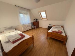een slaapkamer met twee bedden en een spiegel bij Szomszéd Ház in Keszthely