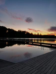 a sunset over a lake with a wooden dock at Domek Łagów Lubuski in Łagów