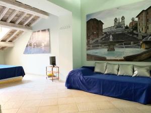 a bedroom with a blue bed and a painting on the wall at Piazza Di Spagna Prestige in Rome