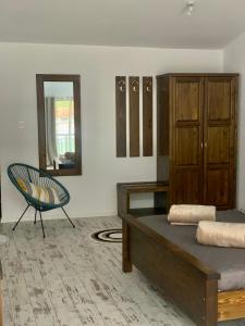 a bedroom with a bed and a chair and a mirror at Комплекс Варвара - Хотел, Аквапарк и Минерлни басейни in Varvara