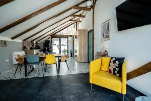 a living room with a yellow couch and a table at Vila Blanc Valiug Crivaia in Văliug