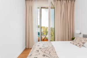 una camera da letto con un letto bianco e un balcone di APARTAMENTY MIERZEJA - MARINA, Kąty Rybackie, Klimatyzacja,100 m od Zalewu Wiślanego a Kąty Rybackie