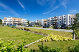 una fila di condomini in un parcheggio di APARTAMENTY MIERZEJA - MARINA, Kąty Rybackie, Klimatyzacja,100 m od Zalewu Wiślanego a Kąty Rybackie