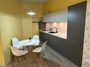 a kitchen with a table and chairs and a sink at Heart of Saint Peter Apartments in Rīga