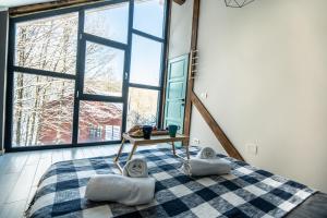 a bedroom with a bed with two pillows and a table at Vila Blanc Valiug Crivaia in Văliug