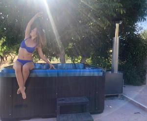 a woman in a bikini sitting on top of a hot tub at La Fuente Retreat in Lecrin