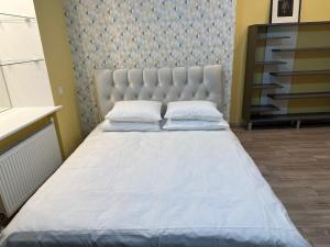 a bedroom with a large bed with a headboard at Heart of Saint Peter Apartments in Rīga
