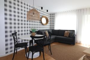 a living room with a couch and a table and chairs at Casa "Patota" - Nazaré - Alojamento Local in Nazaré