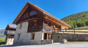 un bâtiment avec un toit en bois sur une montagne dans l'établissement Chalet prestige 14 pers au pied des pistes, à Ceillac
