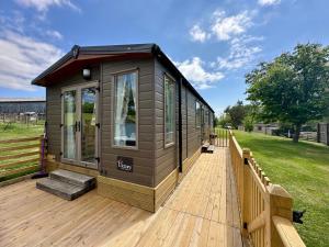 a tiny house sitting on a wooden deck at Fallow Cabin in Pilsdon
