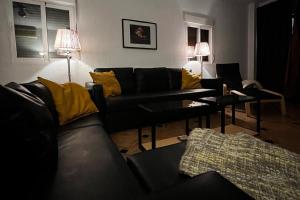 a living room with a black couch and yellow pillows at Lovely 10-Bed Villa with Private Pool & Garden in Cacin