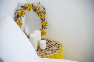 伊亞的住宿－完美靜純別墅，圆镜子,上面有蜡烛和花朵,放在黄色的桌子上