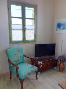 a living room with a chair and a tv at Monemvasia's Art House in Ayía Kiriakí