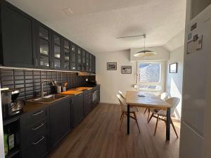 cocina con armarios negros y mesa de madera en Ref 073 Appartement T3 rénové vue Port du Crouesty avec internet, en Arzon 3 fotos más