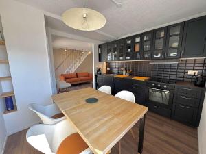 Una cocina con una mesa de madera y algunas sillas. en Ref 073 Appartement T3 rénové vue Port du Crouesty avec internet, en Arzon
