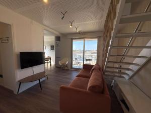 Una sala de estar con un sofá y un televisor. en Ref 073 Appartement T3 rénové vue Port du Crouesty avec internet, en Arzon