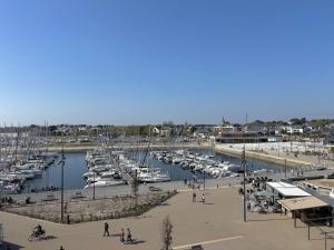 un puerto deportivo con barcos en el agua y gente caminando en Ref 073 Appartement T3 rénové vue Port du Crouesty avec internet, en Arzon