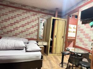 a bedroom with a bed and a table and a tv at Thapa Home Stay in Pokhara