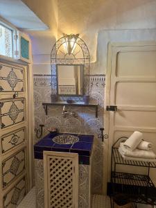 ein Badezimmer mit blauer Waschtischplatte und Spiegel in der Unterkunft Riad Hotel Sherazade in Marrakesch + 64 Fotos