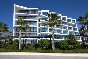 a white building with palm trees in front of it at Luxury Premium Finese in Golem