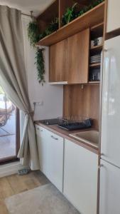 Una cocina con gabinetes blancos y un refrigerador. en Olive Coast Apartments Baošići Center, en Herceg-Novi